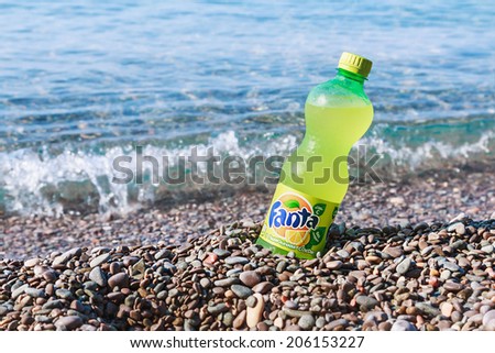 YALTA, Crimea - June 9, 2014: Fanta bottle on the beach. Fanta soft A highly refreshing drink with orange flavor, a trademark owned by The Coca-Cola Company