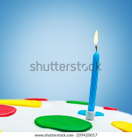 Lighted candles on a birthday cake on a blue background