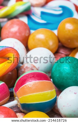 multi colored lollipop and chewing gum batskground. Focus on the colored candies in the foreground