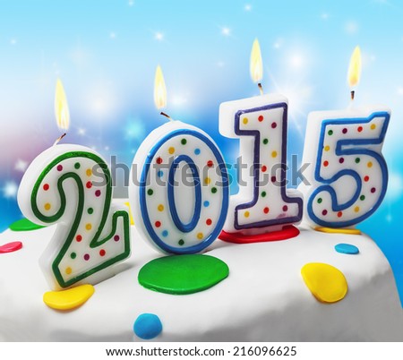 burning candles with the symbol of the new year 2015 on the cake. focus on the first numbers