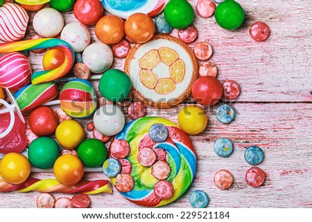 multicolored sweets and chewing gum on a wooden table.