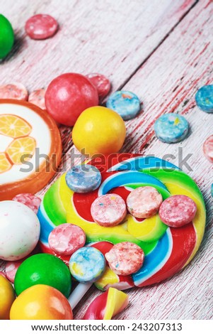 multicolored sweets and chewing gum on a wooden table