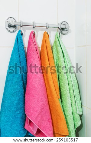 colored towels hanging on the rack in the bathroom