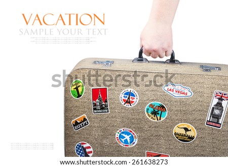 hand holding a retro suitcase with stickers isolated on white background. Text for example, and can be easily removed
