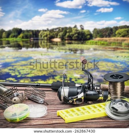 fishing tackle on a wooden float on a background of forest lake. Focus on Fishing Tackle