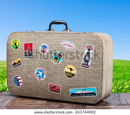 old travel suitcase on background with grass field. focus on a suitcase