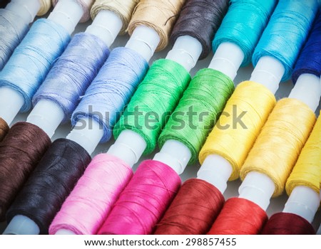 Multicolor sewing threads on background. focus in the center of the frame. Shallow depth of field