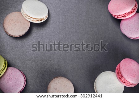 Sweet and colourful french macaroons on a black background. focus on the black background. Background can be used for text