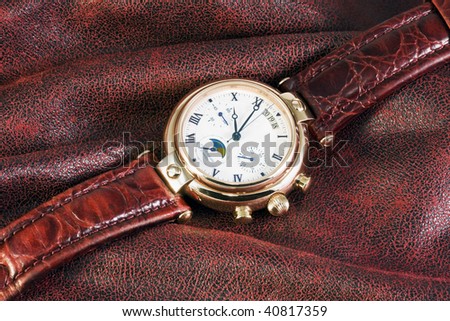 modern chronograph watch lie on burgundy fabric