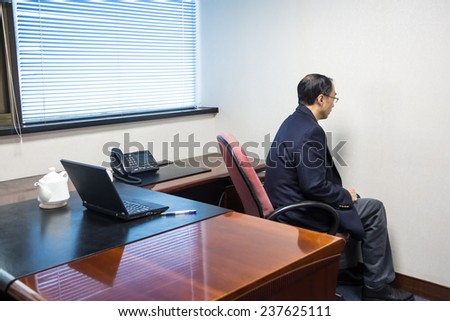 Man with OCD facing white wall in his office
