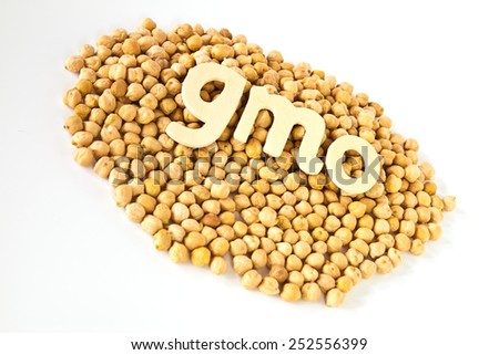 Group chickpeas around wooden letters that read \'\'GMO \'\'