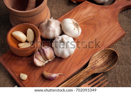 Garlic. sliced garlic, garlic clove, garlic bulb in wooden bowl place on chopping block on vintage wooden background. Place for text,  copy space Concept of healthy food.