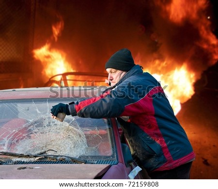 Street riots - Man demolishing car