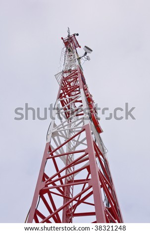 Cell phone and tv communications mast with cloudy blue sky space