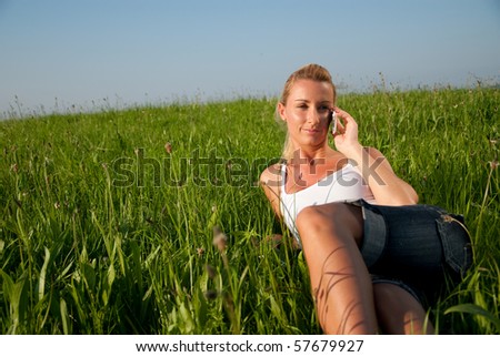 young woman is in the meadow and make phone calls