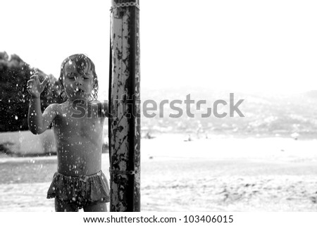 Little girl cooling in the shower on a hot day