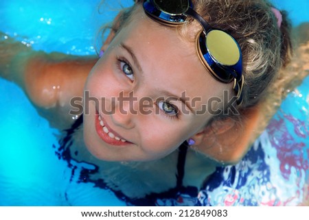 A young girl learns to swim in the pool