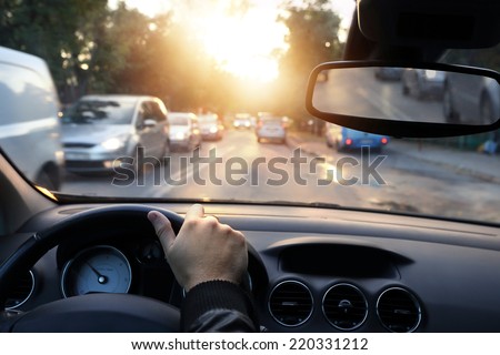 Driving car around town in sunny end of a day