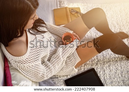 girl in a loose dress sitting on bed