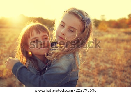 two girls running around the sunny field