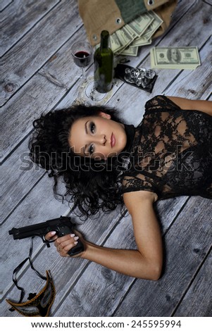 Young girl with a gun money and a bottle of wine