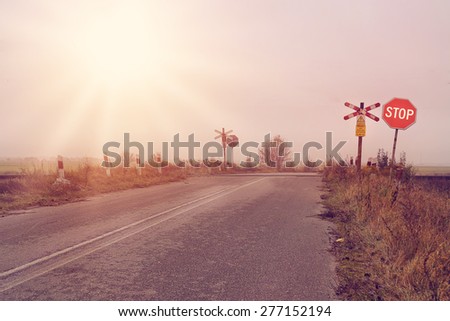 Stop sign on a rural road on rail crossing