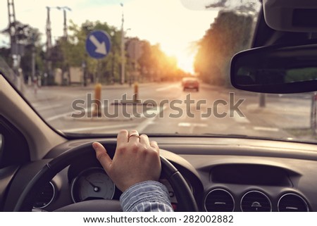 The driver with hand on the steering wheel