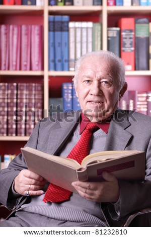 Old man reads a book in the library