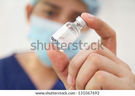 Nurse Checking A Vial Of Medicine.
