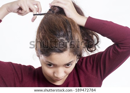 Young lady fixing a messy frizzy hair.