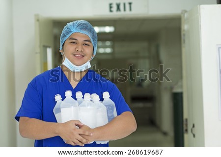 Happy asian male nurse with a bunch of iv fluids.