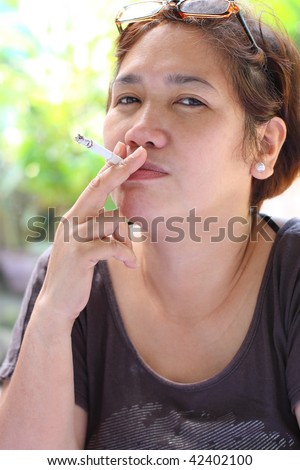 stock photo mature asian woman smoking a cigarette