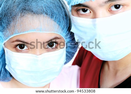 Close up of health workers wearing medical caps and masks.