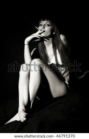 Portrait of beautiful young mode smoking cigatet in black and white - analog grain added