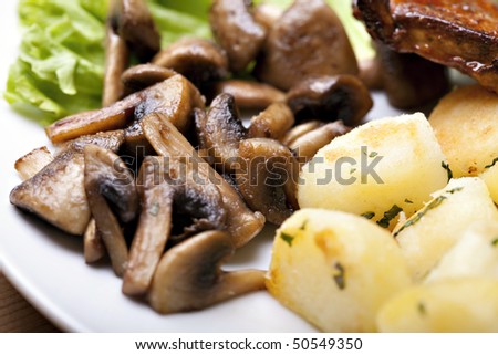 Tasty grilled food, chicken meat, roasted potatoes and mushrooms and sallet