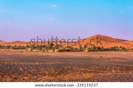 The frontier in the Sahara desert between the flat rocky land and the sand dunes. This interface is perfect for the construction of hotels, used by the tourists interested in the region.