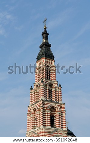 The bell tower of the Cathedral of the Annunciation in Kharkov on a background of blue sky with light clouds. Vertical view