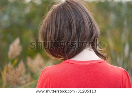 A young women in red shirt standing back