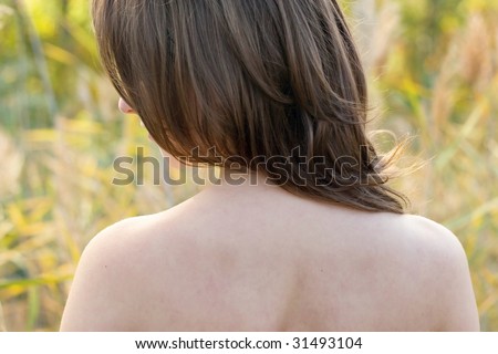 A young women with long hair and naked shoulders,behind standing back