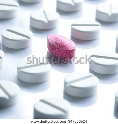 Pills Medicine Tablets in a row. White. One red pill.