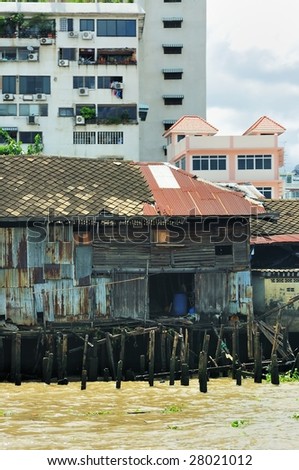 Bangkok: detail from river. Old shack and new buildings. Thailand