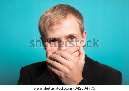 successful business man covers her mouth with a beard and mustache, office style studio photo isolated on a blue background