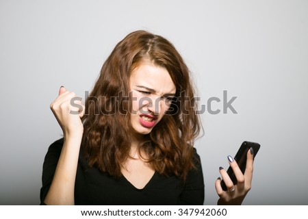 beautiful girl looking angry on the phone, office manager concept shot isolated on gray background