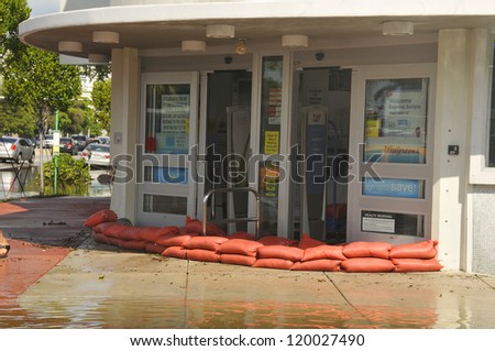 MIAMI - SOUTH BEACH - FLORIDA, OCTOBER 28: People put sand bags in front door of a store in Miami South beach Lenox Ave flood aftermath of Hurricane Sandy on october 28 2012 in Miami South Beach.