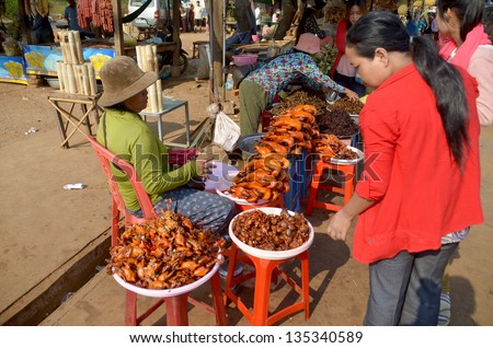 KAMPONG THUM CAMBODIA MARCH 26: People sale fried bugs, spiders, crickets and little birds on march 26 2013 in Kampong Thum Cambodia. About 30% of Cambodians live below the national poverty line