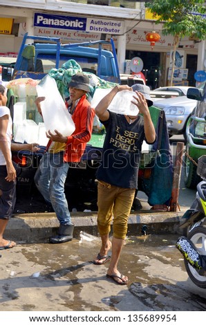 PHNOM PHEN CAMBODIA MARCH 26: Young man delivery ice a the central market on march 26 2013 in Phnom Phen Cambodia. Because lack of refrigeration in Cambodia, ice is manufactured centrally.