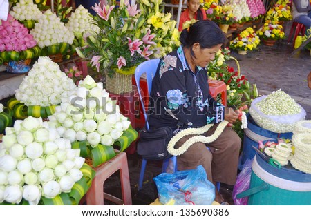 PHNOM PHEN CAMBODIA MARCH 26: Woman make flower bouquets an necklaces for donation a the Buddha a the central market on march 26 2013 in Phnom Phen Cambodia.