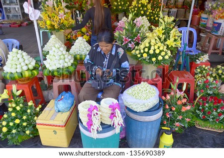 PHNOM PHEN CAMBODIA MARCH 26: Woman make flower bouquets an necklaces for donation a the Buddha a the central market on march 26 2013 in Phnom Phen Cambodia.