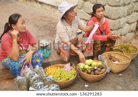 LUANG PRABANG LAOS MARCH 31: Woman sells fruit on the street on march 31 2013 in Luang Prabang Laos. Laos is one of the least developed countries in the world.