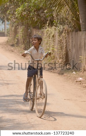 PHNOM PHEN, CAMBODIA MARCH 23: Unidentified street child biking on march 23 2013 in Phnom Phen,Cambodia.In Phnom Penh alone there are between 10,000 and 20,000 children live and work on the streets